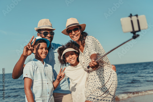 family taking selfie on beach