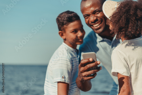 father and kids using smartphone