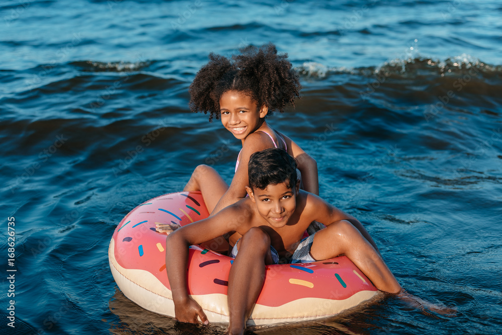 Obraz premium african american siblings on swimming tube