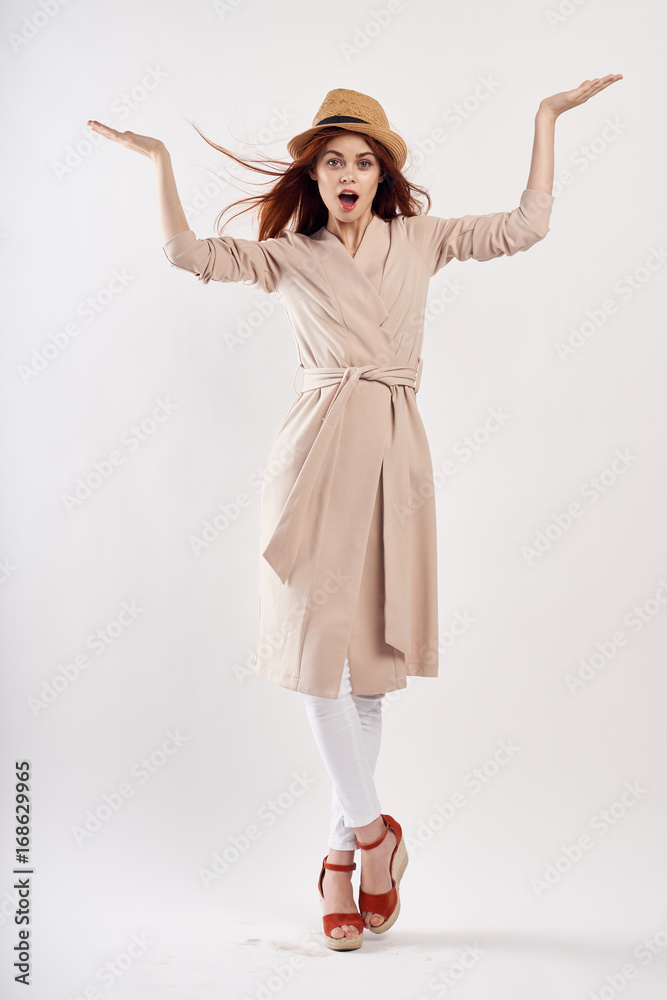Beautiful young woman on a light background with glasses and a hat, emotions, full-length Beautiful young woman on a light background with glasses and a hat, emotions, full-length