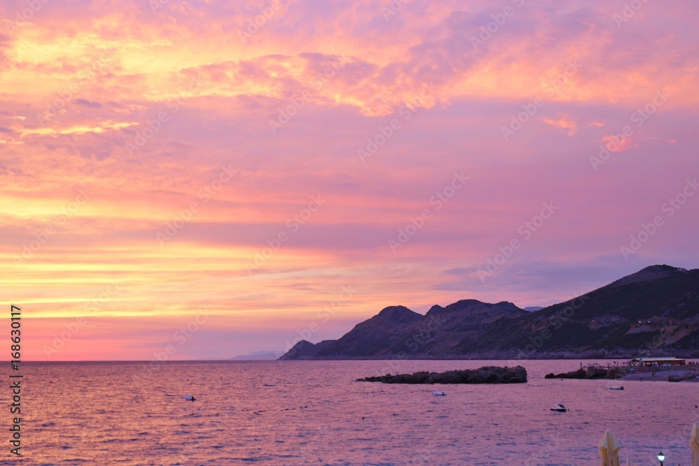Bright colored sunset sky above the sea. On the coast of Dobra Voda, Montenegro, south-east Europe.