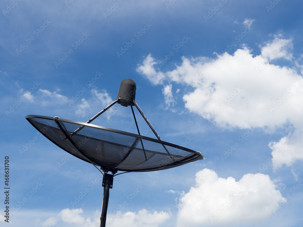 Black satellite dish or TV antennas install on the house roof on blue sky cloudy background.