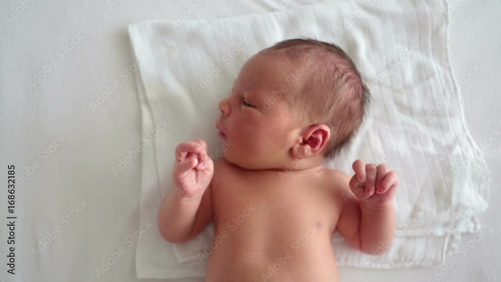 Little newborn baby boy, lying in bed, moving Little newborn baby boy, lying in bed, moving