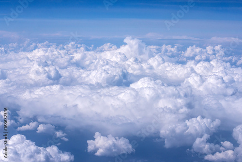 View of blue sky above the clouds from airplane window © Artem