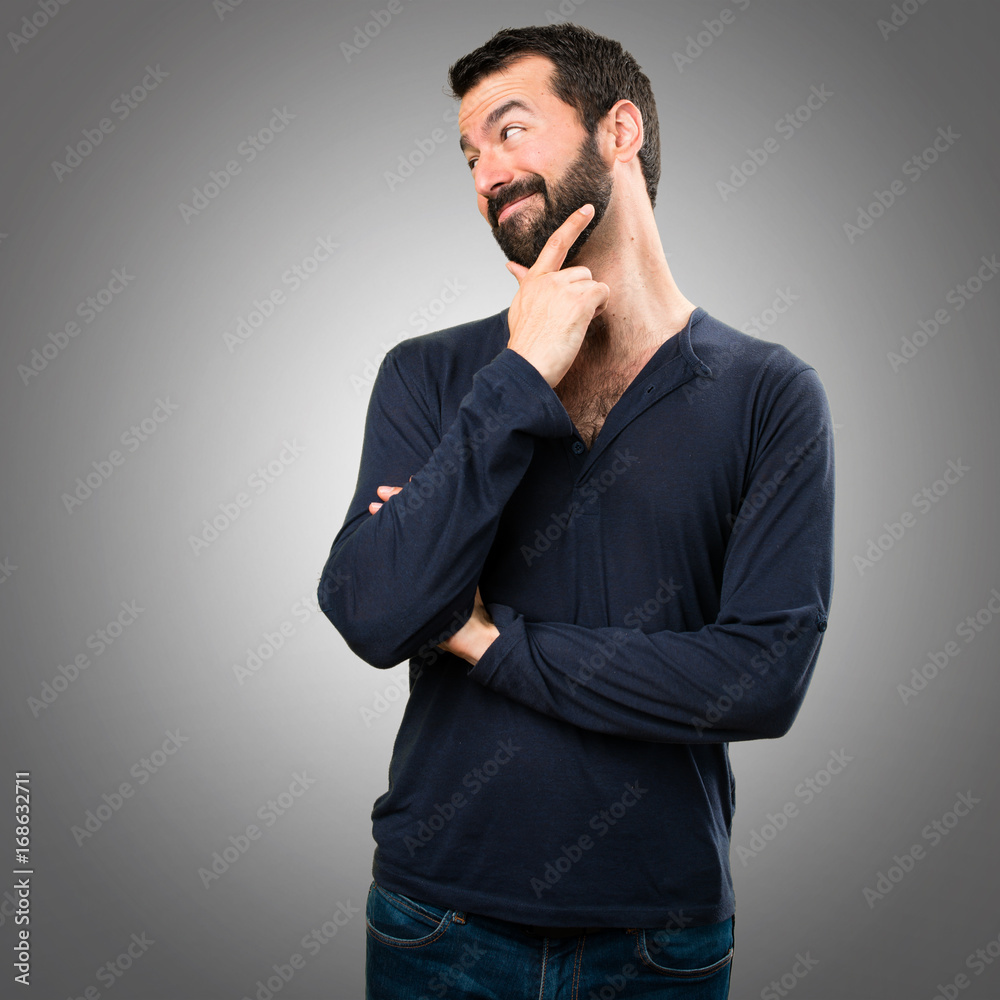 Handsome man with beard looking lateral on grey background Handsome man with beard looking lateral on grey background