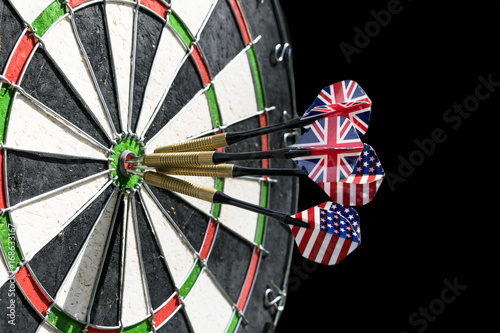 Metal darts have hit the red bullseye on a dart board. Darts Game. Darts arrow in the target center darts in bull's eye close up. Success hitting