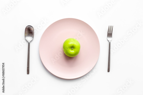 Slimming diet. Apple at plate on white background top view