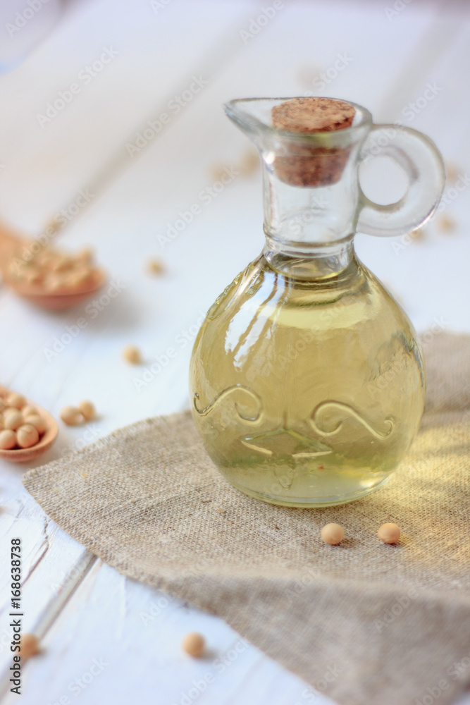 Soy bean oil in glass bottle with soybeans around it. Soy bean oil in glass bottle with soybeans around it.