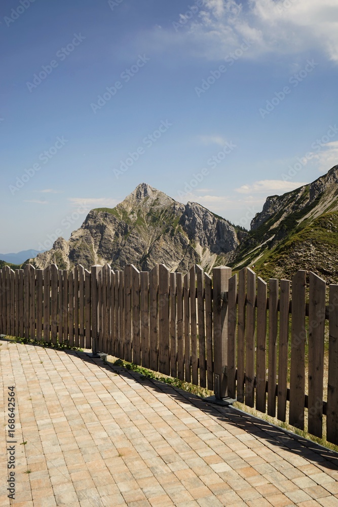 Fototapeta premium Wooden fence in the Alps under blue sky