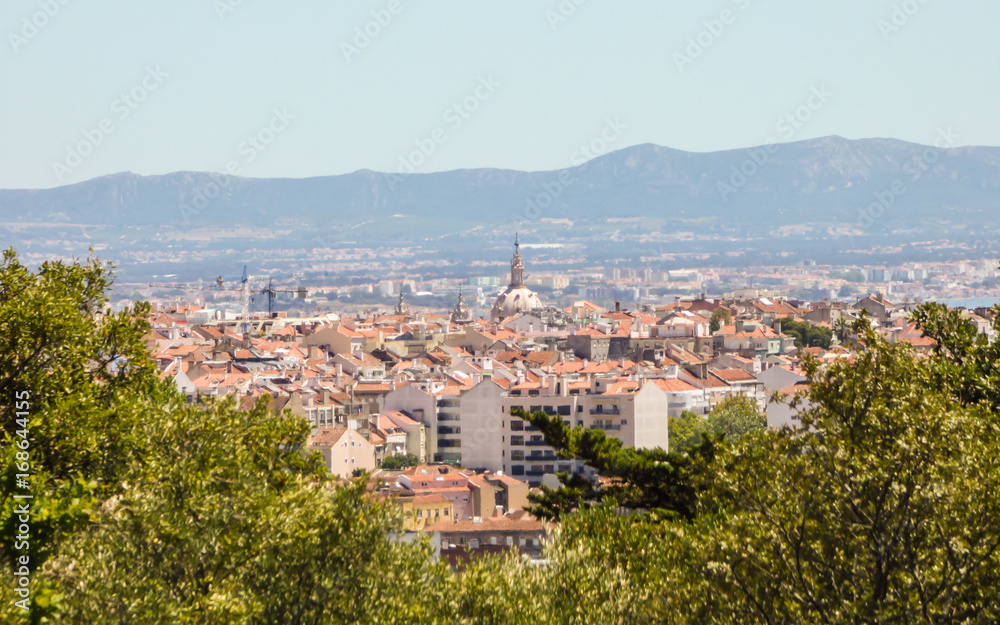 A view of Lisbon from the viewpoint from Parque Recreativo do Alto da Serafina at Monsanto Forest Park - mountain chain in the background