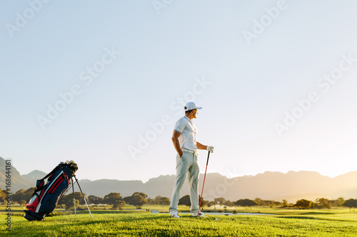 Professional male golfer with golf club at course