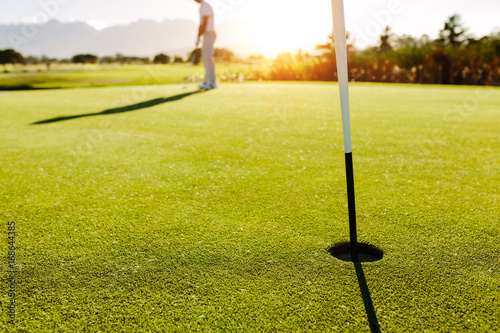 Golf hole and flag in the green field