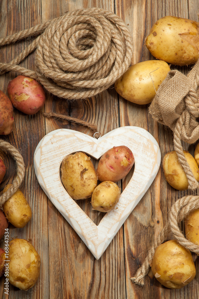 Potatoes and heart on a wooden background Potatoes and heart on a wooden background