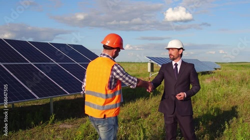 On footage director metting foreman in the field at solar energy station. Chief showing to worker project objectives.