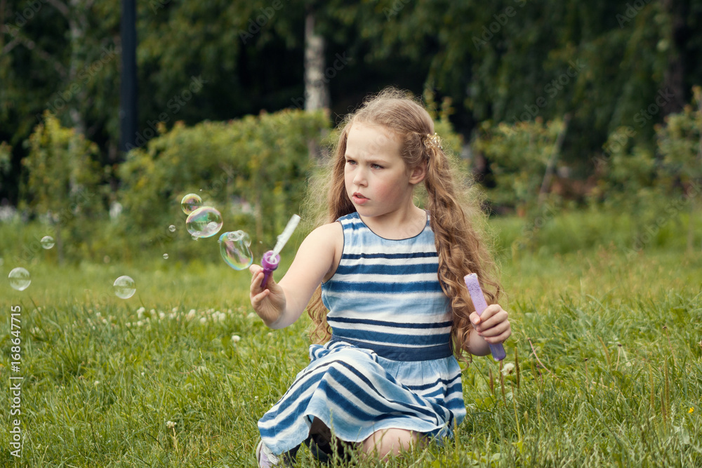Little child girl playing with soap bubble in summer park Little child girl playing with soap bubble in summer park