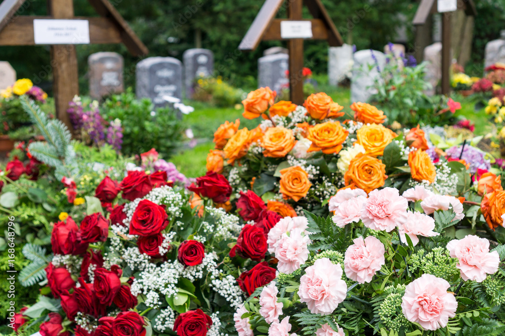 flowers on a grave at the cemetery StockFoto Adobe Stock