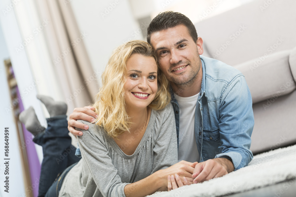 Happy young couple layed on the carpet of their living room Happy young couple layed on the carpet of their living room