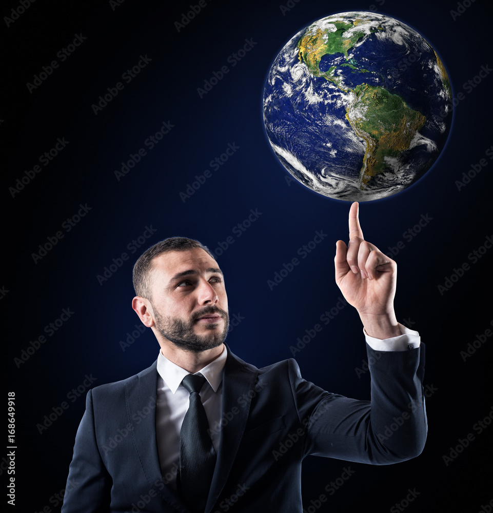 Businessman holds the world with a finger. World provided by NASA Businessman holds the world with a finger. World provided by NASA