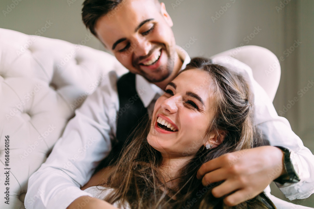 Φωτογραφία A young couple in love having fun on a sofa and playing with a hair of the girl