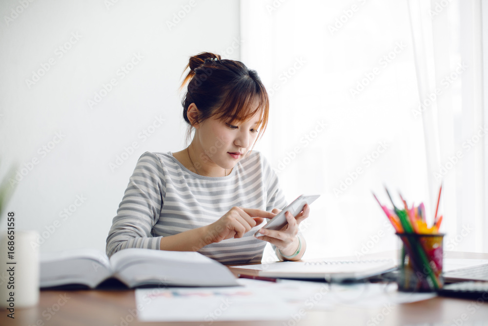 Young Asia woman working with smart phone at home Young Asia woman working with smart phone at home