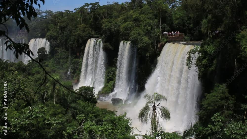Tourists stand on top of one of many waterfalls in Iguazu National Park in in the Brazil and Argentina border Tourists stand on top of one of many waterfalls in Iguazu National Park in in the Brazil and Argentina border