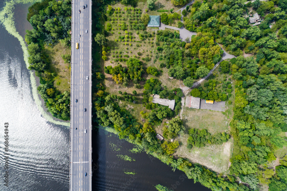 Aerial view of the bridge and the road over the Dnepr River over a green island in the middle of the river. Kiev, Ukraine