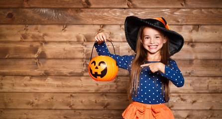 funny child girl in witch costume in halloween