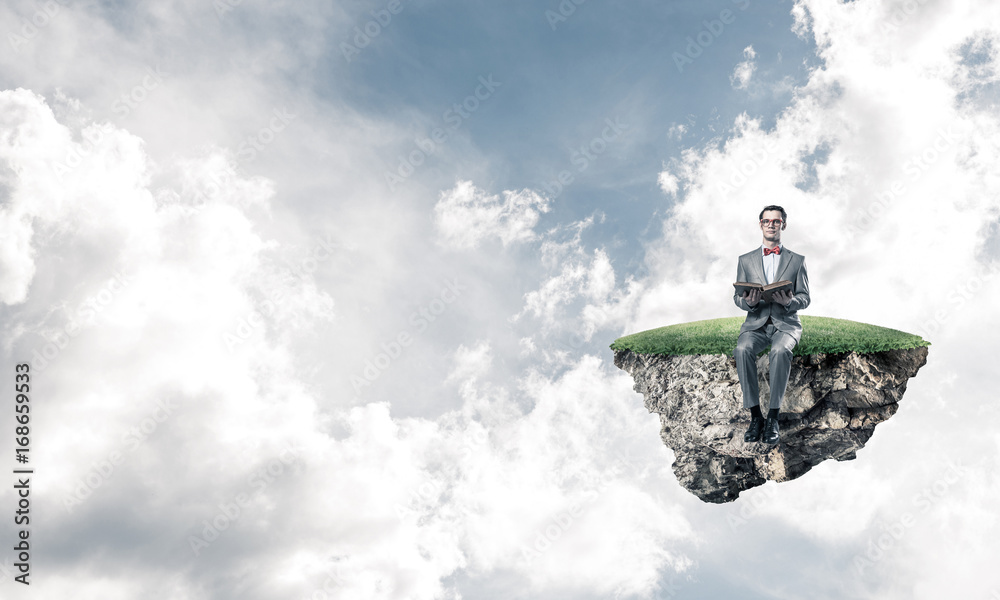 Young businessman or student floating in sky and studying the sc Young businessman or student floating in sky and studying the sc