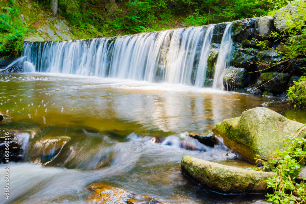 Obraz premium Beautiful small waterfall on nice creek in forest