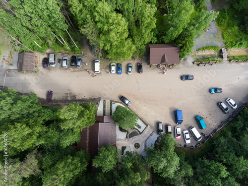 Car parking is in the territory of the Kivach Reserve. A view from above on the wooden houses of museums, the ticket office and entrance gate. Karelia, Russia