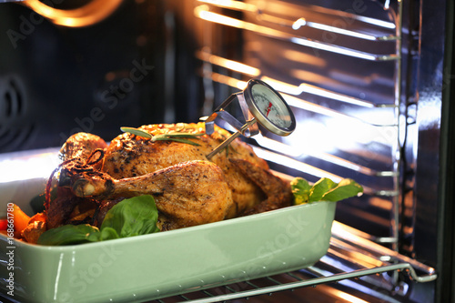 Golden roasted turkey in oven with meat thermometer photo