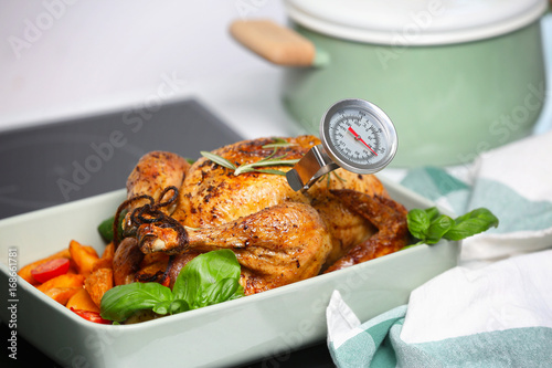 Golden roasted turkey with meat thermometer on table