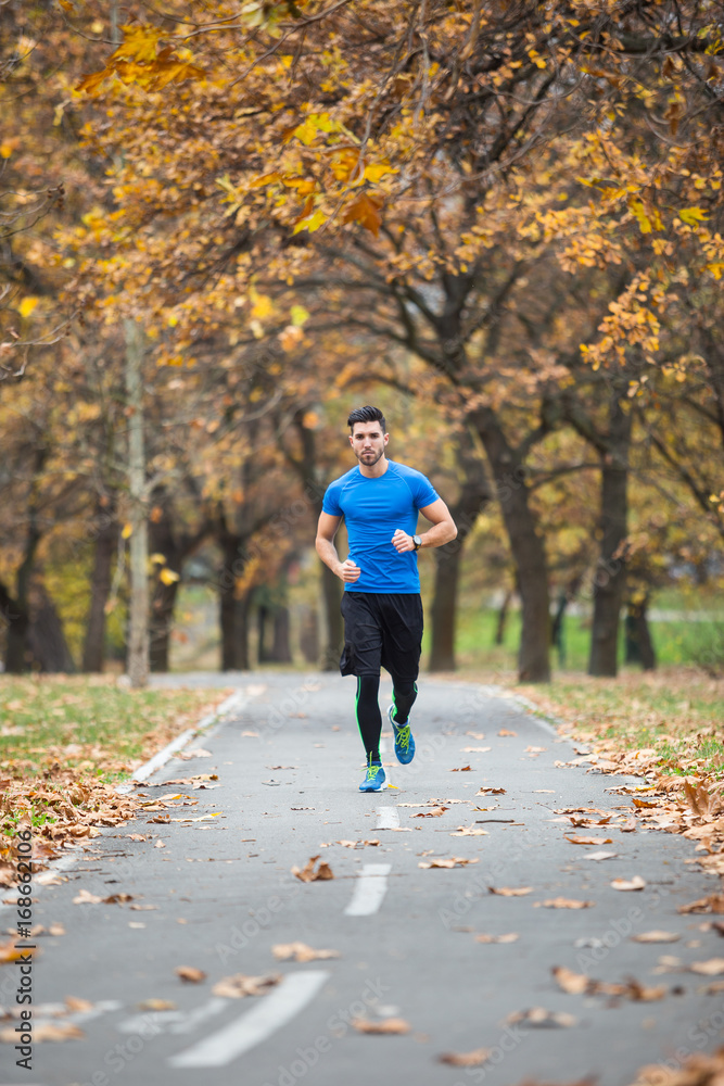 Athletic young man tying laces.Running in the nature. Healthy lifestyle Athletic young man tying laces.Running in the nature. Healthy lifestyle