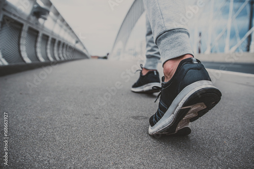 Young man running on the modern bridge in the city