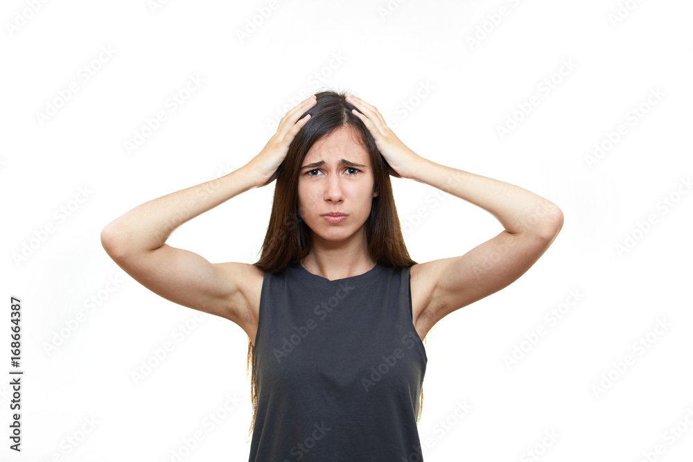 Girl emotions. White background. Portrait of young angry shocked woman holding head Girl emotions. White background. Portrait of young angry shocked woman holding head