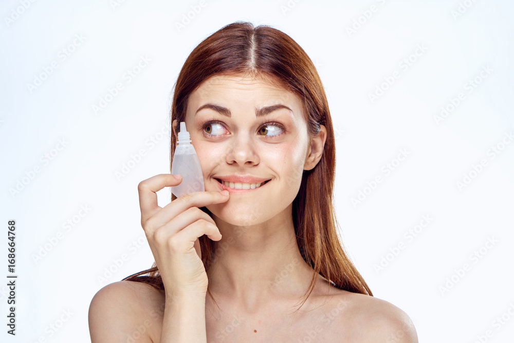 Beautiful woman on a white background holds eye drops, portrait Beautiful woman on a white background holds eye drops, portrait