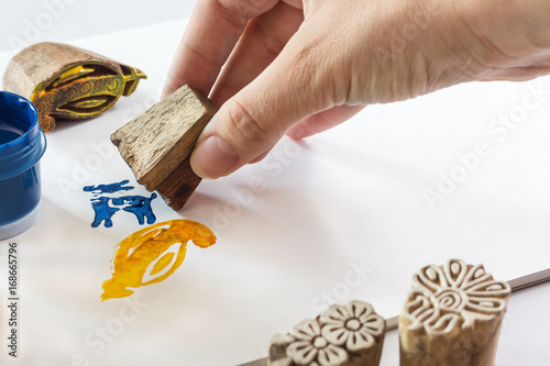 indian stamp blocks composition with hand, paint, brush and paper