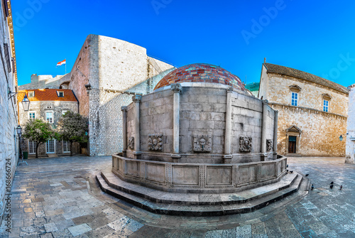 Dubrovnik historic landmarks. / Scenic view inside city walls of Dubrovnik, old Stradun street and marble architecture, Croatia. photo