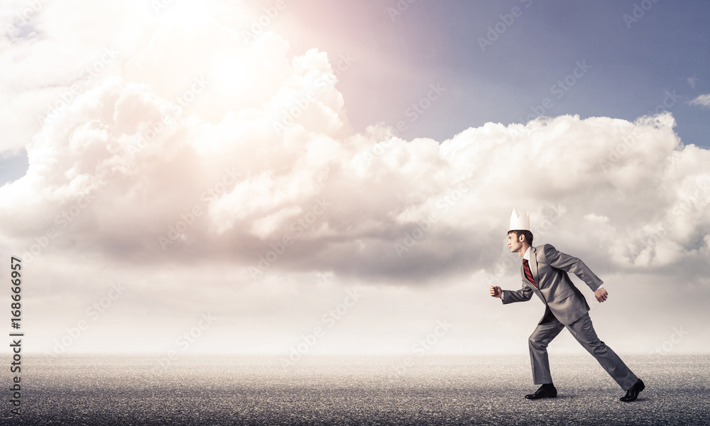 King businessman in elegant suit running and blue sky at backgro