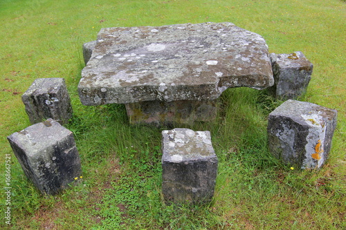 Stone table on a green grass ground