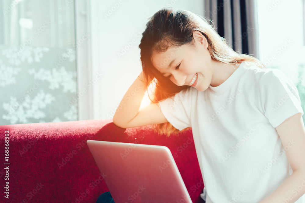 Beautiful young woman using laptop computer smile relaxing in holidays at home on sofa having great living lifestyle. Beautiful young woman using laptop computer smile relaxing in holidays at home on sofa having great living lifestyle.