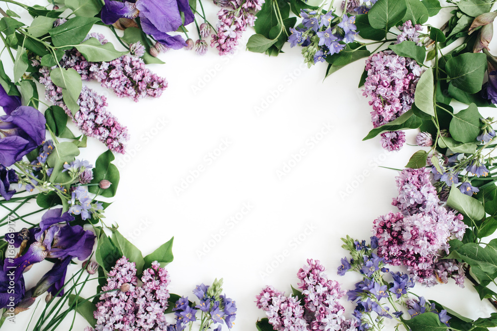 Frame of lilac flowers, branches, leaves and petals with space for text on white background. Flat lay, top view