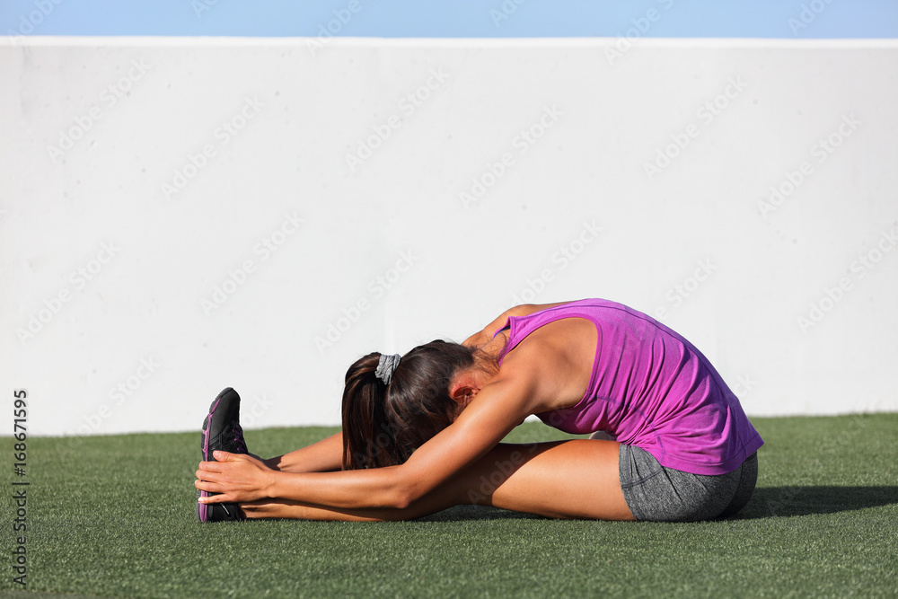 Yoga runner girl stretching back over legs doing seated Forward Bend. Fold  named Paschimottanasana. Active woman doing sitting hamstring stretch  warm-up exercises. Stock Photo