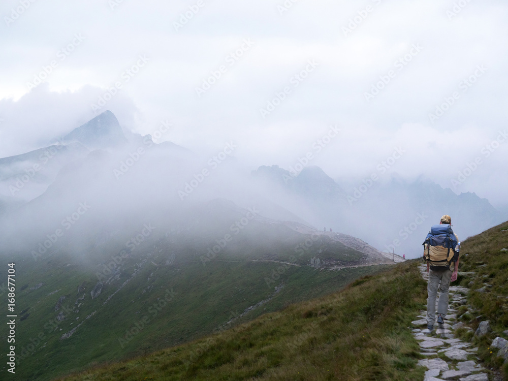 A traveler with a backpack. Morning misty mountain. Hiking.