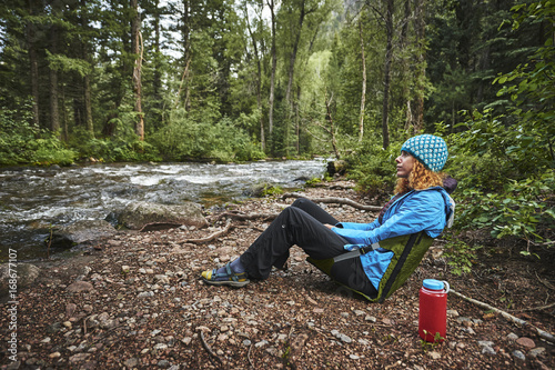 a woman relaxing next to a mountain stream