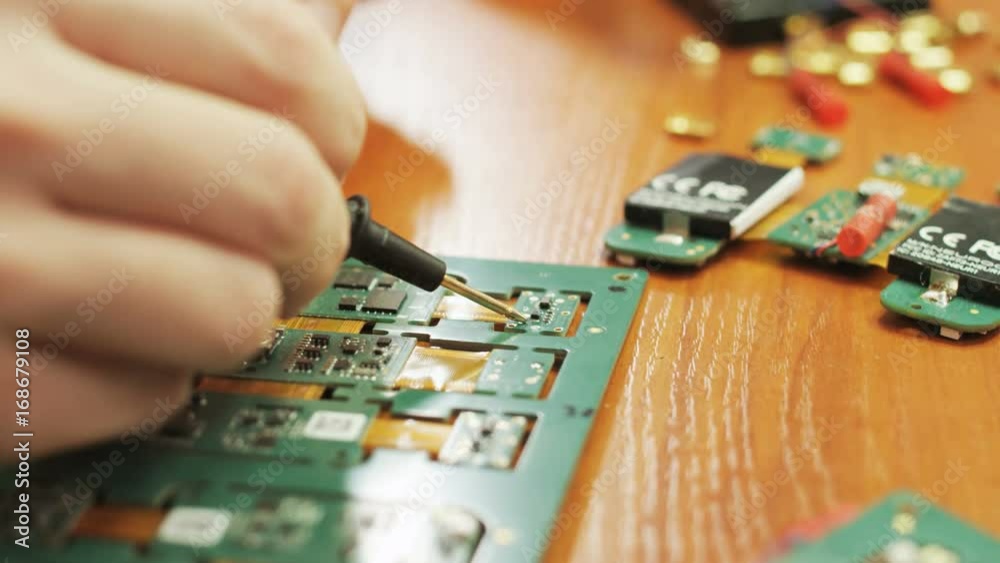 Hands of a Young Man Doing Repair of the Computer Chip Hands of a Young Man Doing Repair of the Computer Chip
