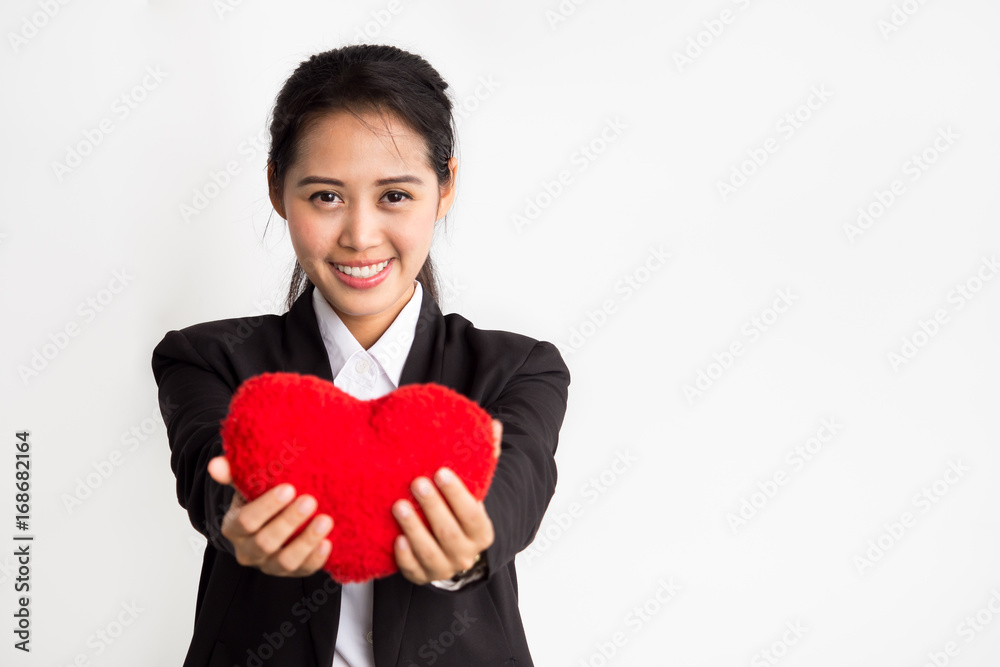 Young asian businesswoman holding red heart on white background, love and teamwork in working place office concept Young asian businesswoman holding red heart on white background, love and teamwork in working place office concept