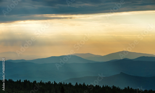 Sun rays at dawn over the mountain range.