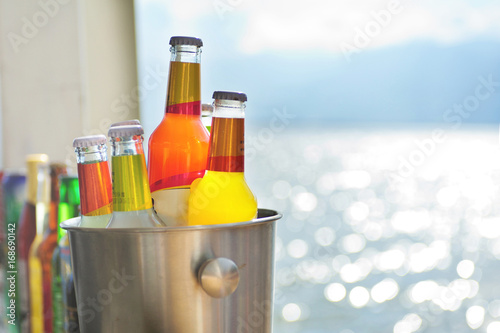 Colorful Bottles placed on the desk beside lake.