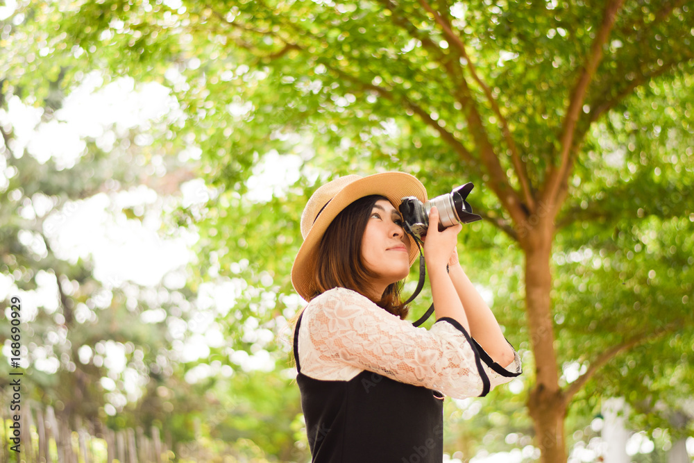 Young Asian woman is enjoy traveling into tropical forest and using mirror less camera. Young Asian woman is enjoy traveling into tropical forest and using mirror less camera.
